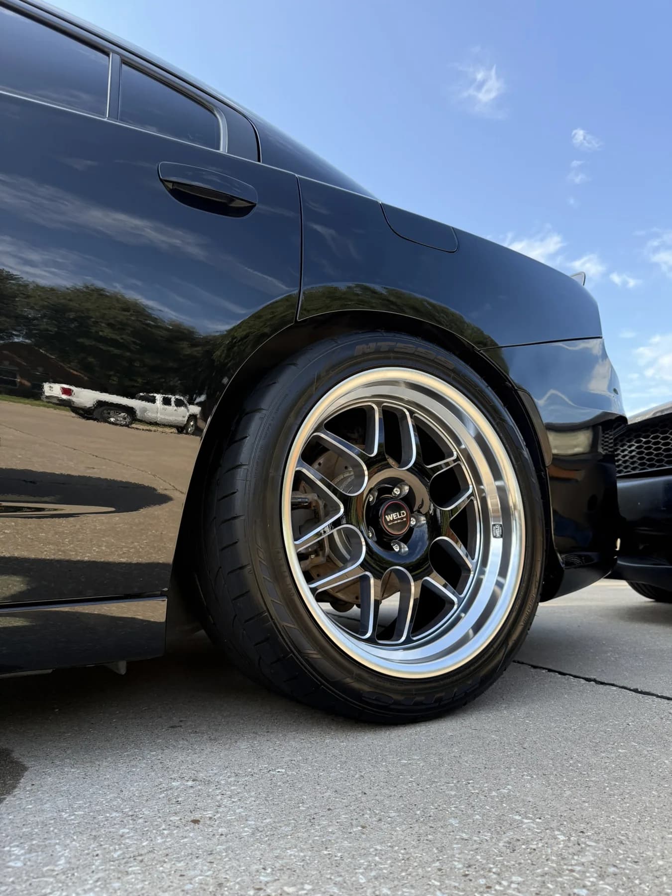 Close view of a BMW wheel and reflective black bodywork