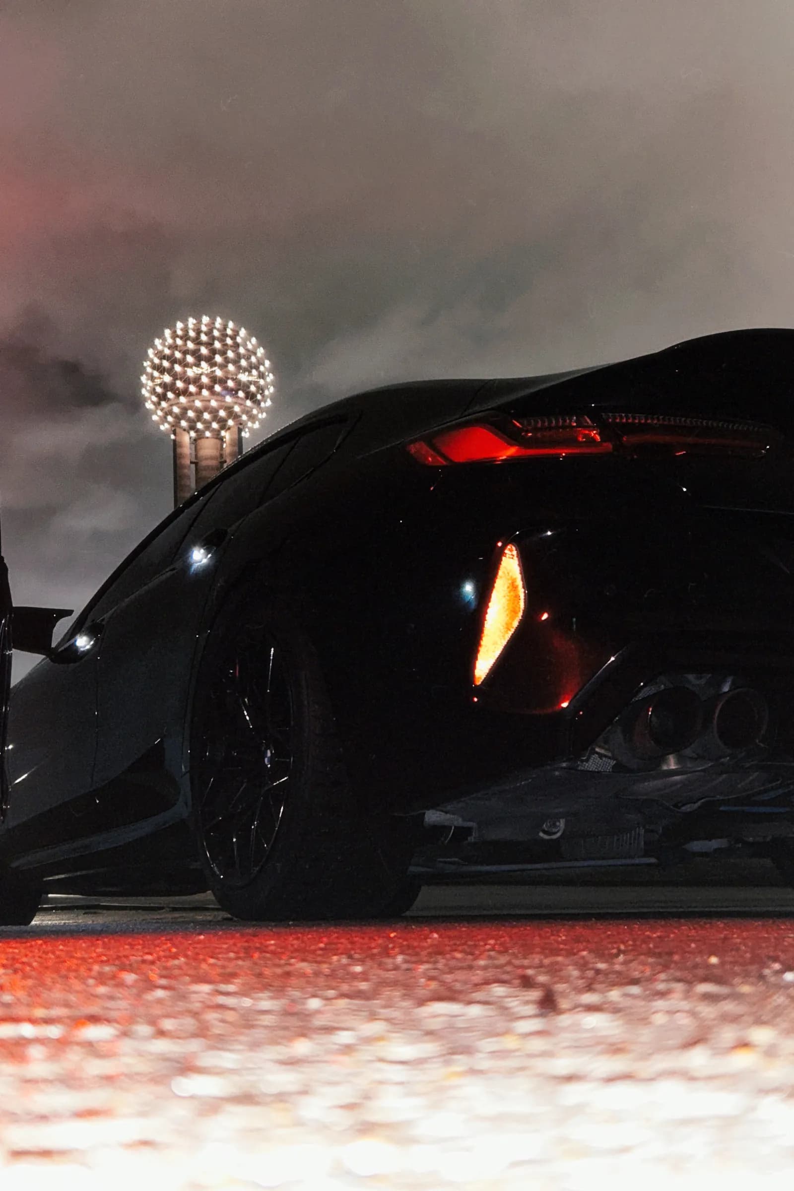 Freshly detailed black sports car at night in Dallas